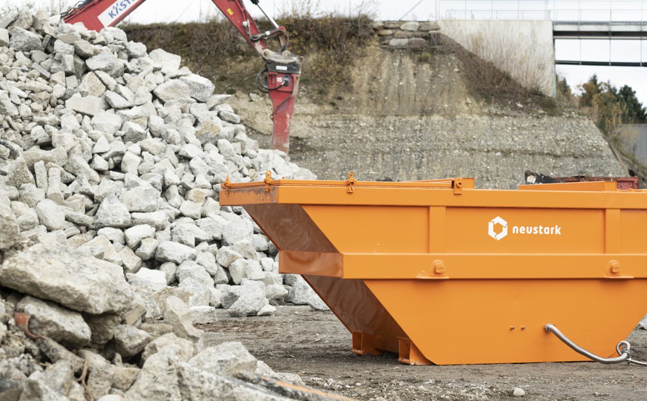 Oranger Container von Neustark steht in einer baulichen Umgebung